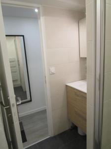 a small bathroom with a sink and a mirror at Appartement Cœur de Ville - Saint Germain en Laye in Saint-Germain-en-Laye