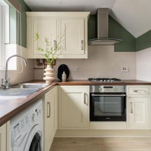 a kitchen with white cabinets and a sink and a dishwasher at The Bracken's by Ritual Stays in Hemel Hempstead