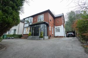 a brick house with a car parked in the driveway at Pillo Rooms - Spacious 4 Bedroom Detached House close to Heaton Park in Manchester