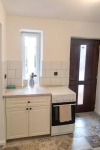 a kitchen with white cabinets and a stove top oven at Marelle Porta in Veresegyház