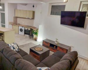 a living room with a couch and a tv on a wall at InTown in Constanţa