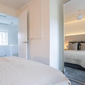 a white bedroom with a bed and a window at The Bracken's by Ritual Stays in Hemel Hempstead