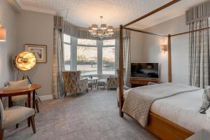 a bedroom with a bed and a desk and a television at The Inn On The Lake in Glenridding +98 photos