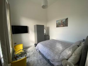 a bedroom with a bed and a flat screen tv at Witheys Lodge in Woodhorn