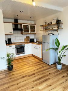 eine Küche mit weißen Geräten und Holzböden in der Unterkunft Auszeit-Winterberg in Winterberg