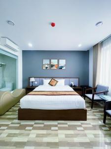 sypialnia z dużym łóżkiem i niebieską ścianą w obiekcie Minh Anh Hotel & Apartment w Hajfong