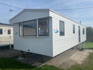 un remolque blanco está estacionado en un patio en No. 1 Family Caravan at Golden Gate Holiday Centre, Sleeps 6, en Abergele