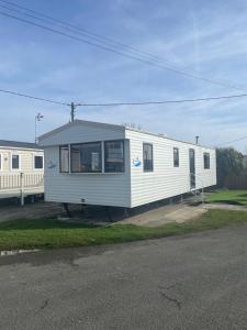 a white mobile home sitting on the side of a street at No. 1 Family Caravan at Golden Gate Holiday Centre, Sleeps 6 in Abergele