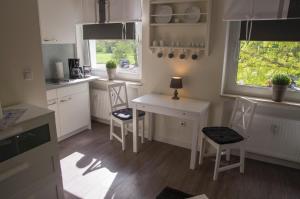 eine Küche mit einem Tisch und Stühlen sowie einem Fenster in der Unterkunft Apartmenthaus Frauenpreis FeWo 61 in Cuxhaven