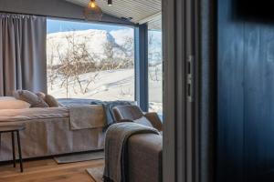 a living room with a couch and a large window at Santa's Hotel Rakka in Kilpisjärvi