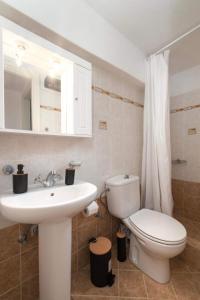 een badkamer met een witte wastafel en een toilet bij BATIS Beach House in Kypri