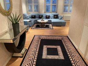 a living room with a blue couch and a rug at Apartament Faltom Gdynia Centrum in Gdynia