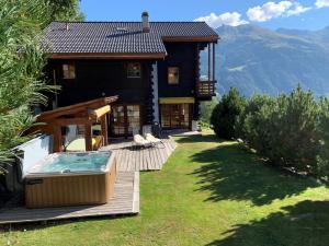 a large house with a hot tub on a deck at Rafaches in Grimentz