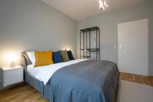 1 dormitorio con 1 cama con almohadas azules y amarillas en Bright stylish apartment in a top location, en Viena