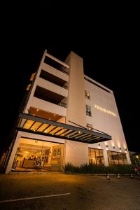 ein großes weißes Gebäude in der Nacht mit Lichtern in der Unterkunft Prado Hotel in Amparo