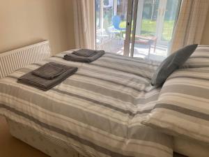 a bed with two towels on top of it at bungalow on the south coast & new forest in Lymington