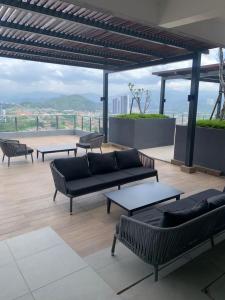 - une terrasse avec des canapés et des tables au-dessus d'un bâtiment dans l'établissement Neu suites 007- 2 bedrooms klcc, à Kuala Lumpur