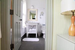 a bathroom with a sink, toilet and mirror at The Porches Inn at Mass MoCA in North Adams
