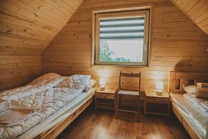 2 camas en una cabaña de madera con ventana en Ferienhaus für 5 Personen ca 60 qm in Osłonino, Pommern Danziger Bucht en Osłonino