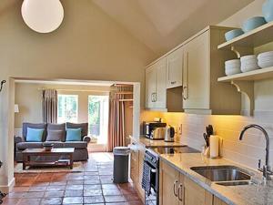 a kitchen with a sink and a living room at The Granary in Stuston