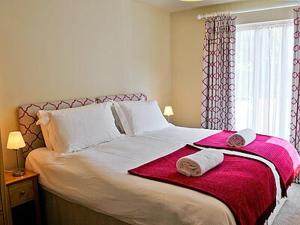 a bedroom with a large bed with two towels on it at The Granary in Stuston
