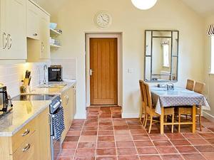 a kitchen with a table and a dining room at The Granary in Stuston