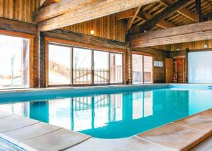 a swimming pool in a building with wooden walls and windows at Bois de Champelle - 14 - Chalet cosy - 6 pers in Morillon