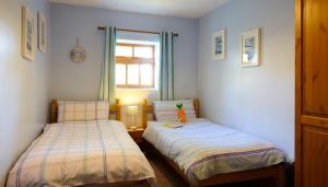 two beds in a small room with a window at Filey Holiday Cottages in Filey