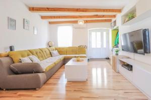 a living room with a couch and a tv at House Leon in Brtonigla