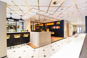 a bar in a restaurant with black cabinets at Quality Hotel Augustin in Trondheim