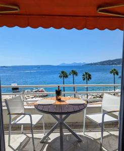 un tavolo su un balcone con vista sulla spiaggia di Superbe appartement vue mer panoramique a Juan-les-Pins