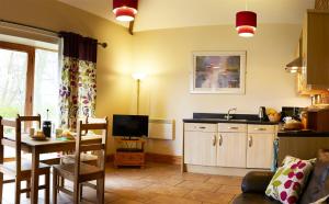 a kitchen and dining room with a table and a television at Filey Holiday Cottages in Filey