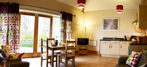 a living room with a table and a kitchen at Filey Holiday Cottages in Filey +31 photos