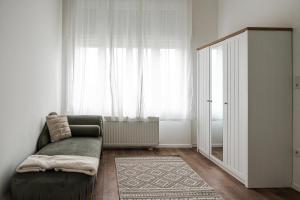 a living room with a couch and a large window at Volenter Lux Apartment Uno in Baja