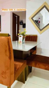 a counter with a table and a chair and a mirror at Lindo apto piscina liberada e próximo à praia QX01H in Solemar +6 photos