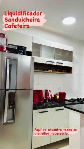 a kitchen with a stainless steel refrigerator in a kitchen at Lindo apto piscina liberada e próximo à praia QX01H in Solemar
