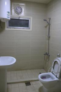 a bathroom with a toilet and a sink and a window at Sakhra hostel in Dubai