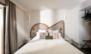 キャヴァレール・シュル・メールにあるHôtel du Parc Cavalaire sur Merのベッドルーム1室(白いシーツと枕のベッド1台付)