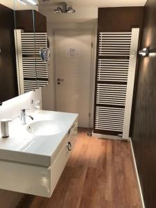 ein Badezimmer mit einem weißen Waschbecken und einem Spiegel in der Unterkunft Exclusive FEWO in Warnemünde, 150m to the beach, 2 bathrooms, 2 bedrooms, sauna, WiFi and much more. in Rostock