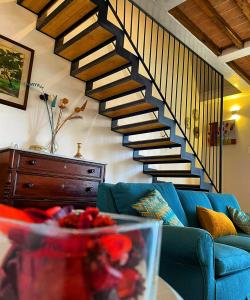 a living room with a blue couch and a staircase at Agriturismo La Corte del Sole in Siena
