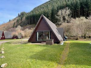 a small cabin in the middle of a grass field at Caledonia Lodge in Spean Bridge