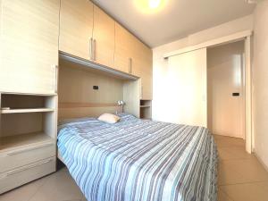 a small bedroom with a bed and a closet at Capitol Apartments in Grado