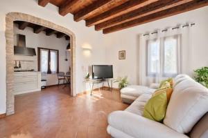 sala de estar con sofá blanco y TV en Villa Navagero - Ca' degli Stefani C en Rovarè
