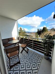 Balcón con 2 sillas, mesa y mesa en Winterberg Appartement 21122, en Winterberg