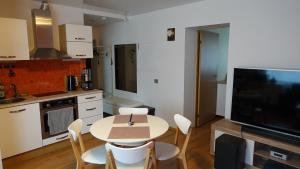 a kitchen with a table and chairs and a television at Cozy Telliskivi apartment near city centre in Tallinn