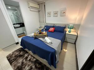 ein Schlafzimmer mit einem blauen Bett und einem Tablett mit Essen darauf in der Unterkunft RIVIERA MANHATTAN - Luxuoso 4 quartos, varanda Gourmet in Aquiraz