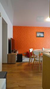 ein Wohnzimmer mit einem Tisch, Stühlen und einem TV in der Unterkunft Cozy Telliskivi apartment near city centre in Tallinn