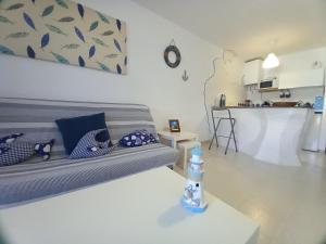 a living room with a couch and a kitchen at Las Islas Apartment in Corralejo