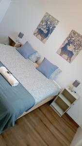 um quarto com uma cama com lençóis e almofadas azuis em Oriente DNA Studios II em Lisboa