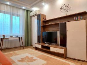 a living room with a flat screen tv at HappyTerra in Almaty